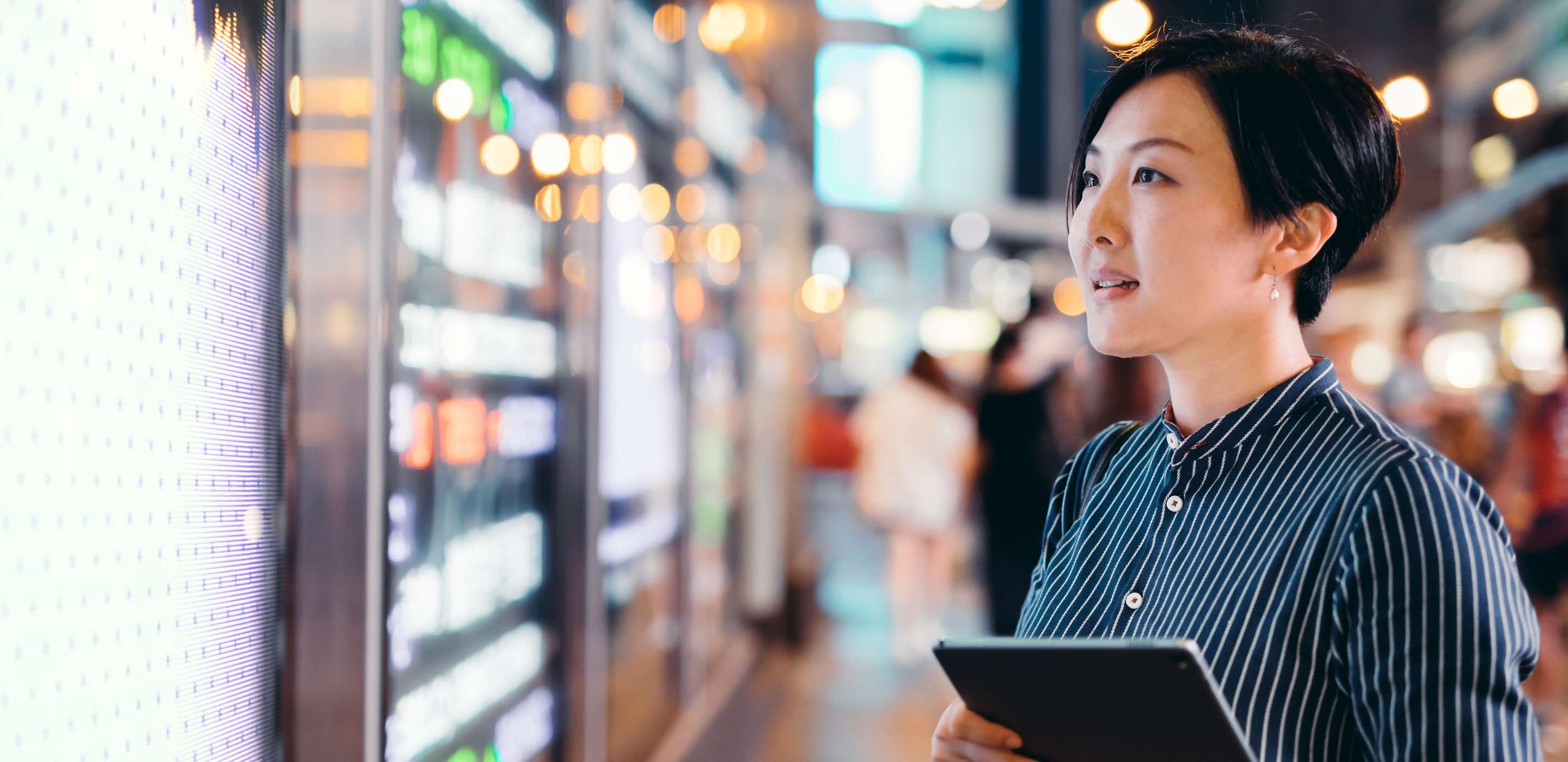 Lady holding a tablet looking at a screen with numbers
