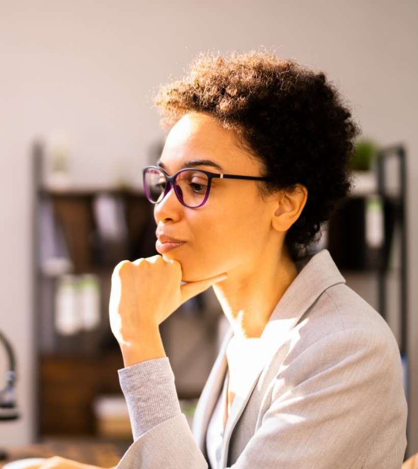 A woman wearing optical glasses looking at two screens with data