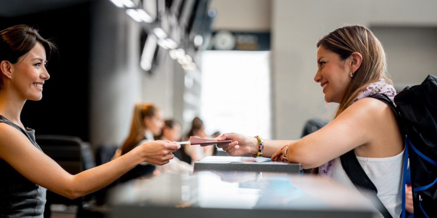 A airport cashier handing over passport to passenger