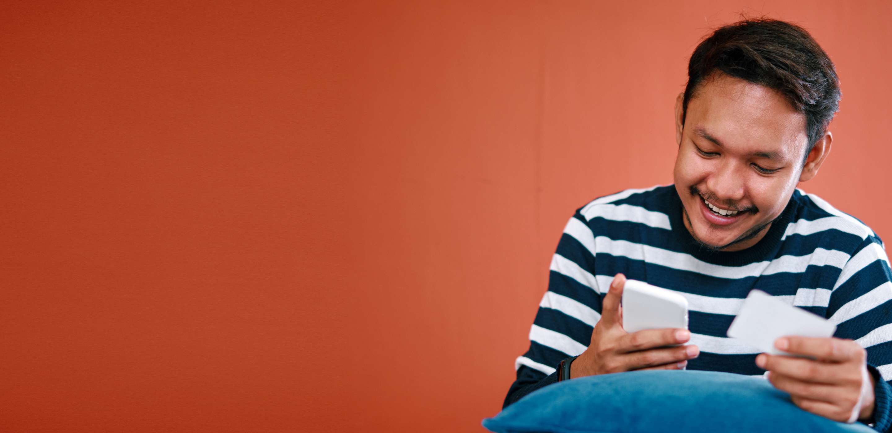 Man looking at cellphone and card