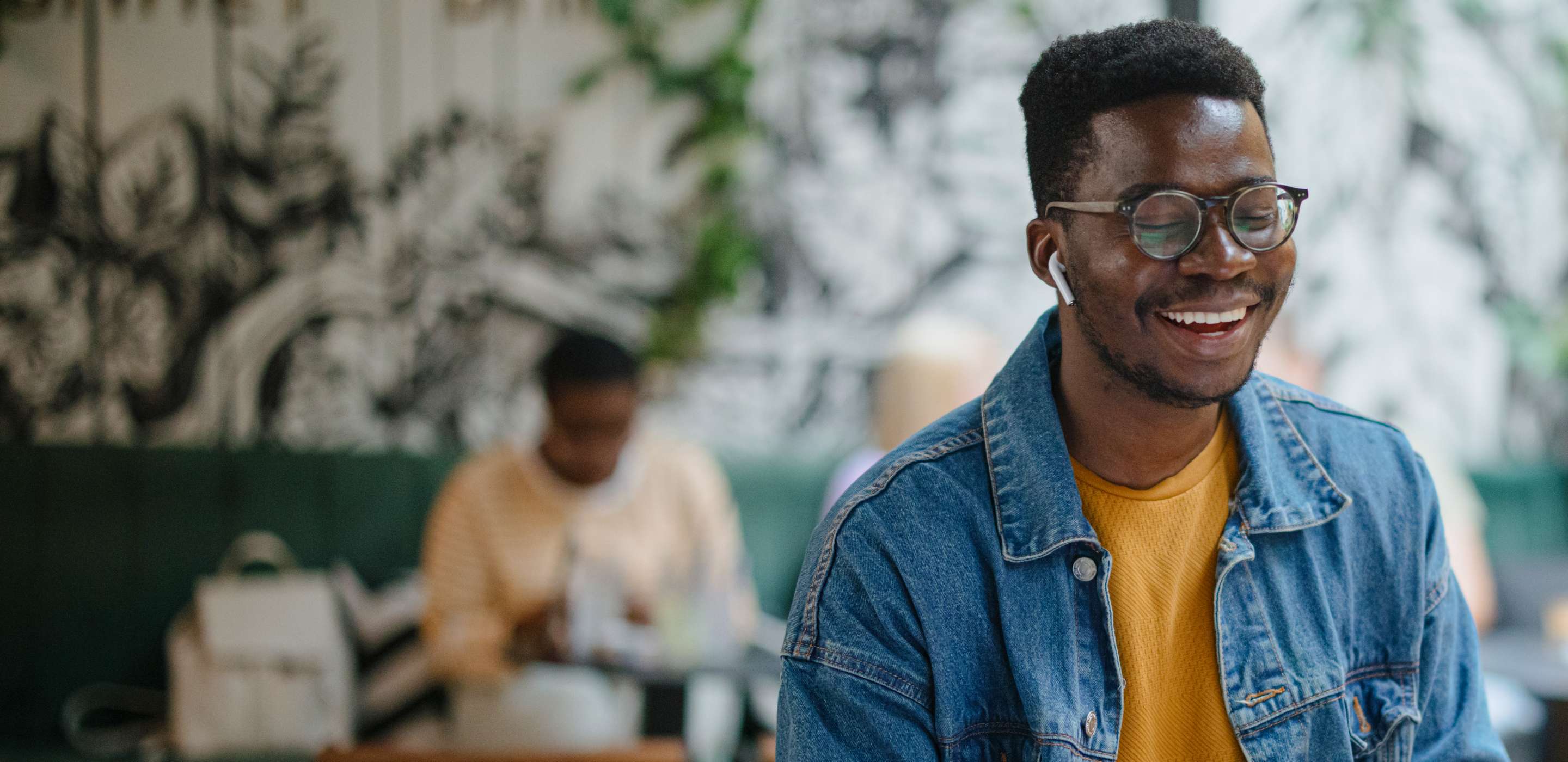 A man with earbuds smiling