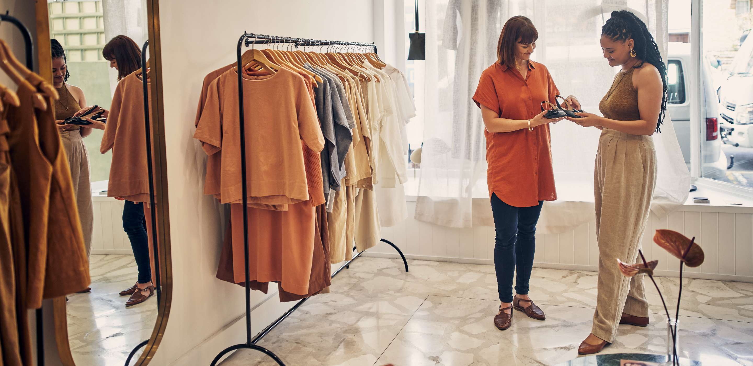 Shot of two young women looking at a pair of shoes in a clothing store