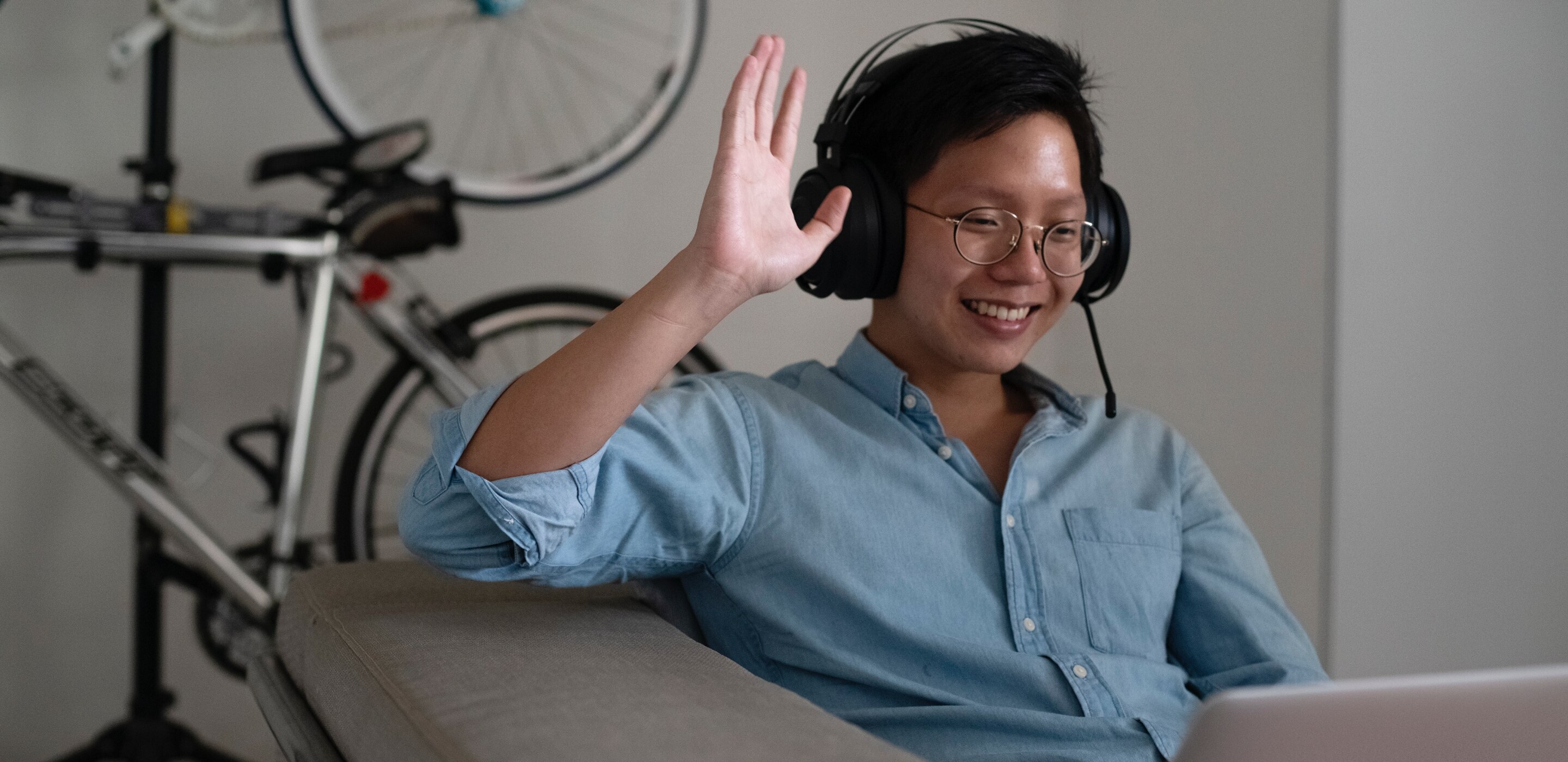 A man waving at a computer screen