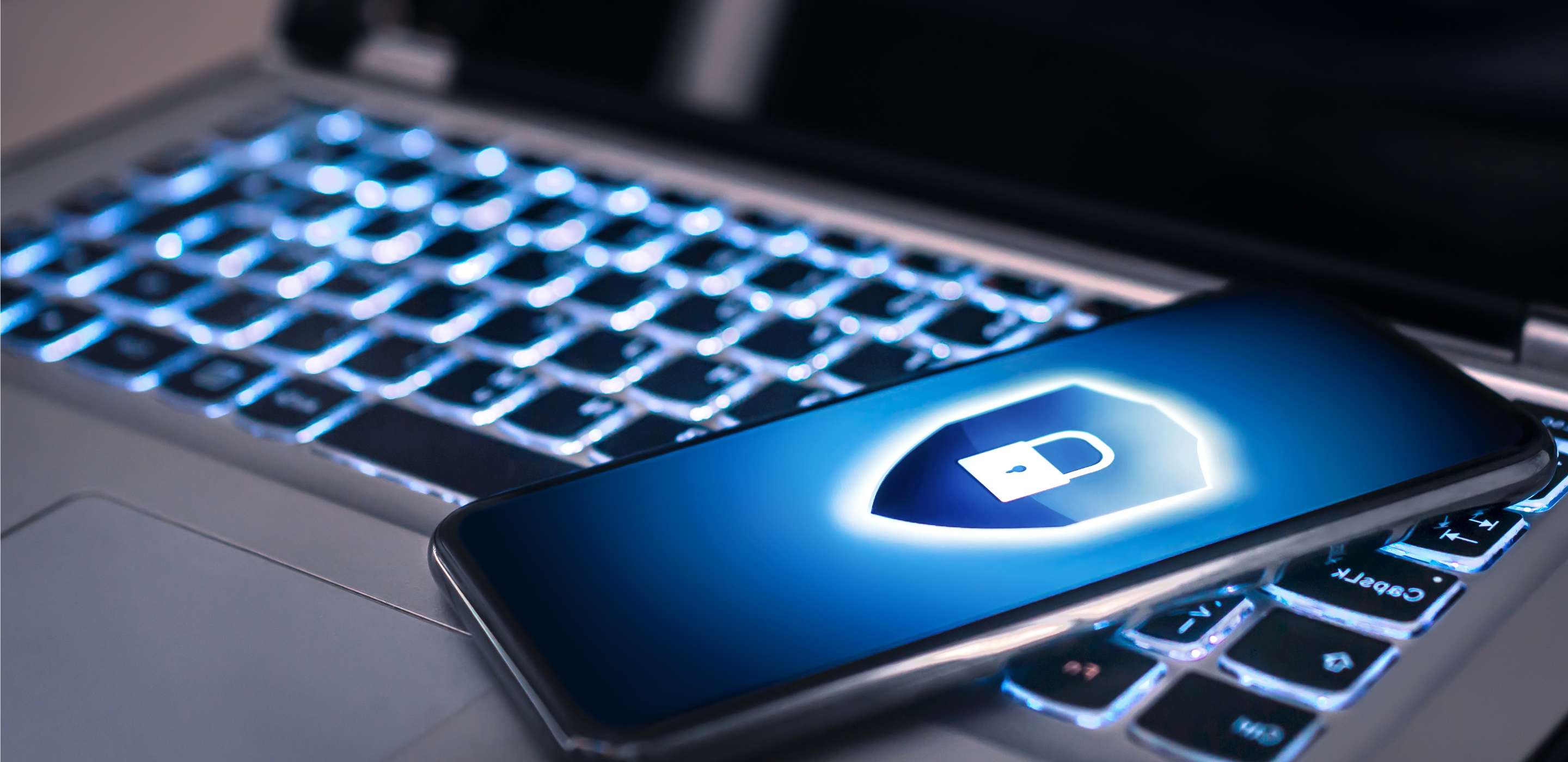 Phone lock to protect from cyber scam, online data fraud or identity theft  lying on laptop keyboard