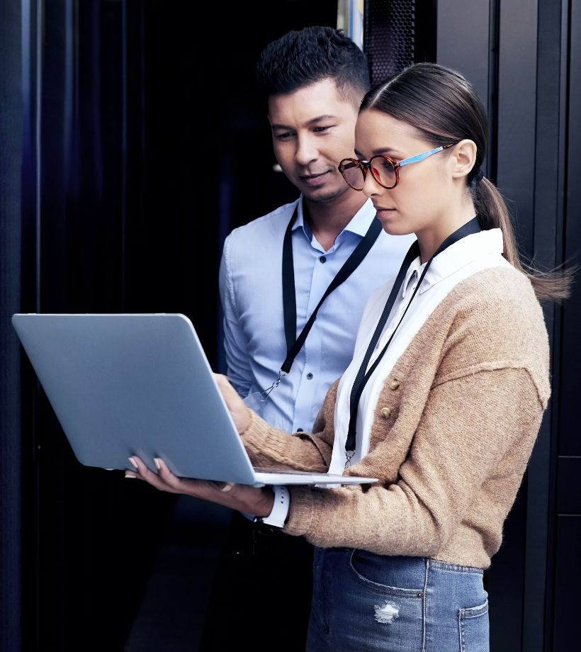 A man and a woman looking at a laptop screen while standing