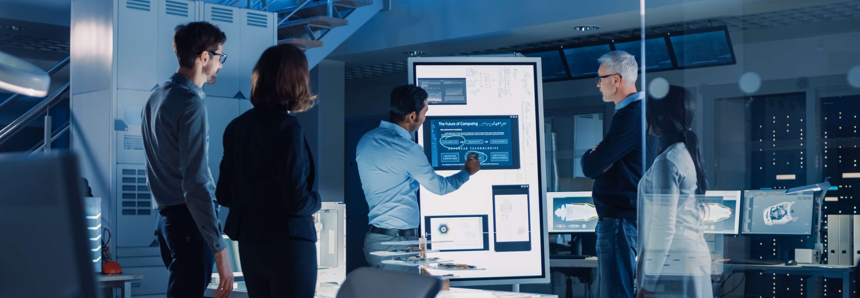 A small group of people looking at a big digital screen