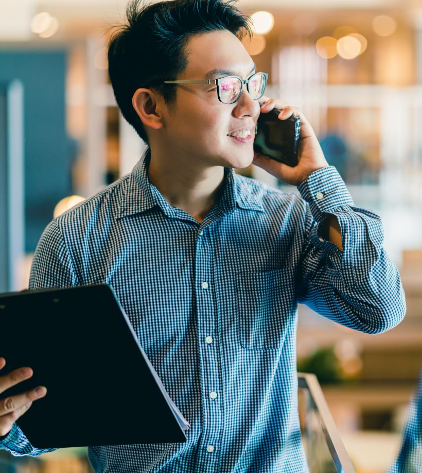 A man on a phone and holding a file