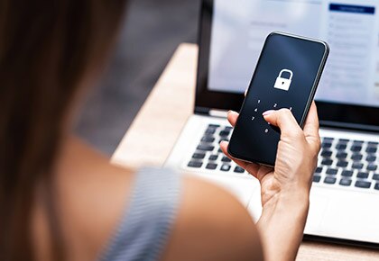 A cellphone locked screen with laptop hehind