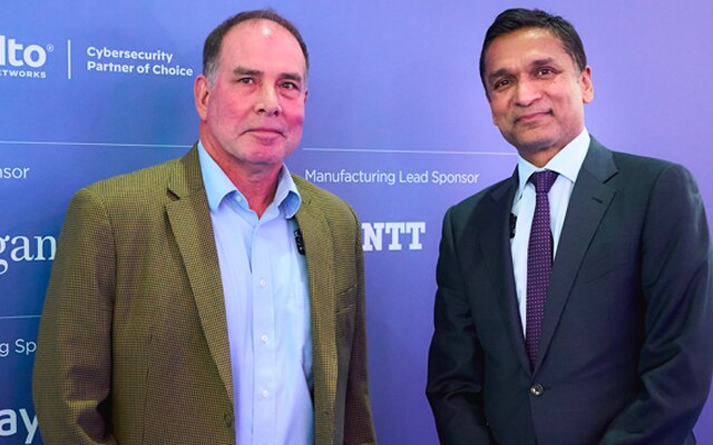 Two man in front of a banner