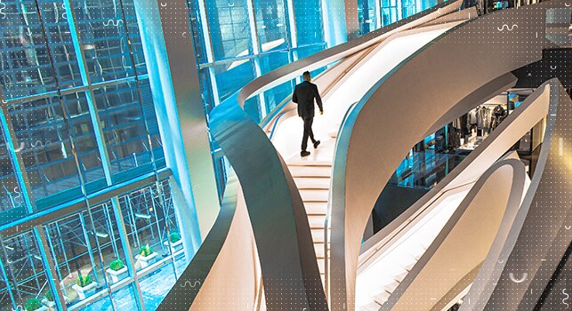 A person walking up steps in an office hall