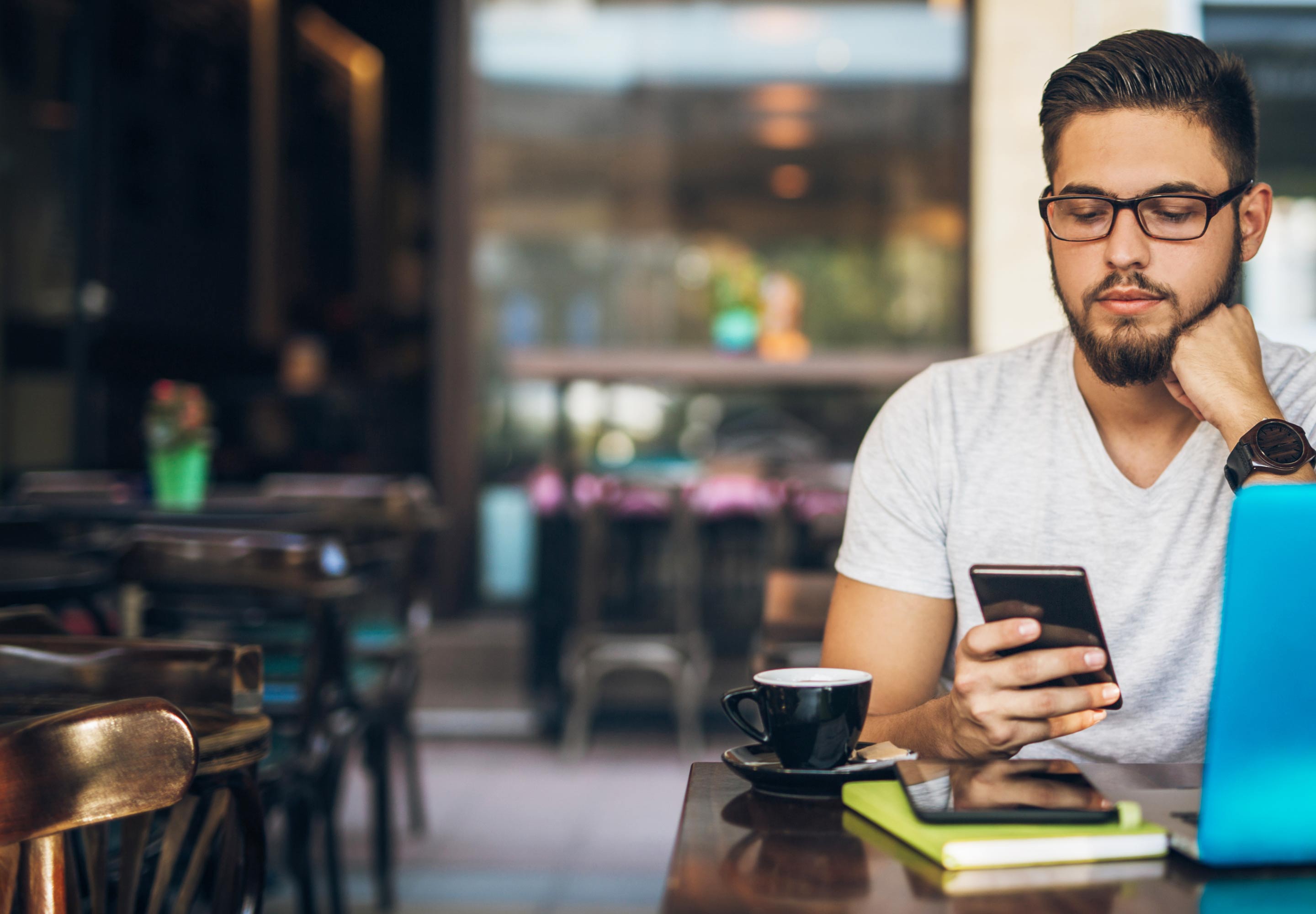 A man sitting in a restaurant looking at cellphone screen