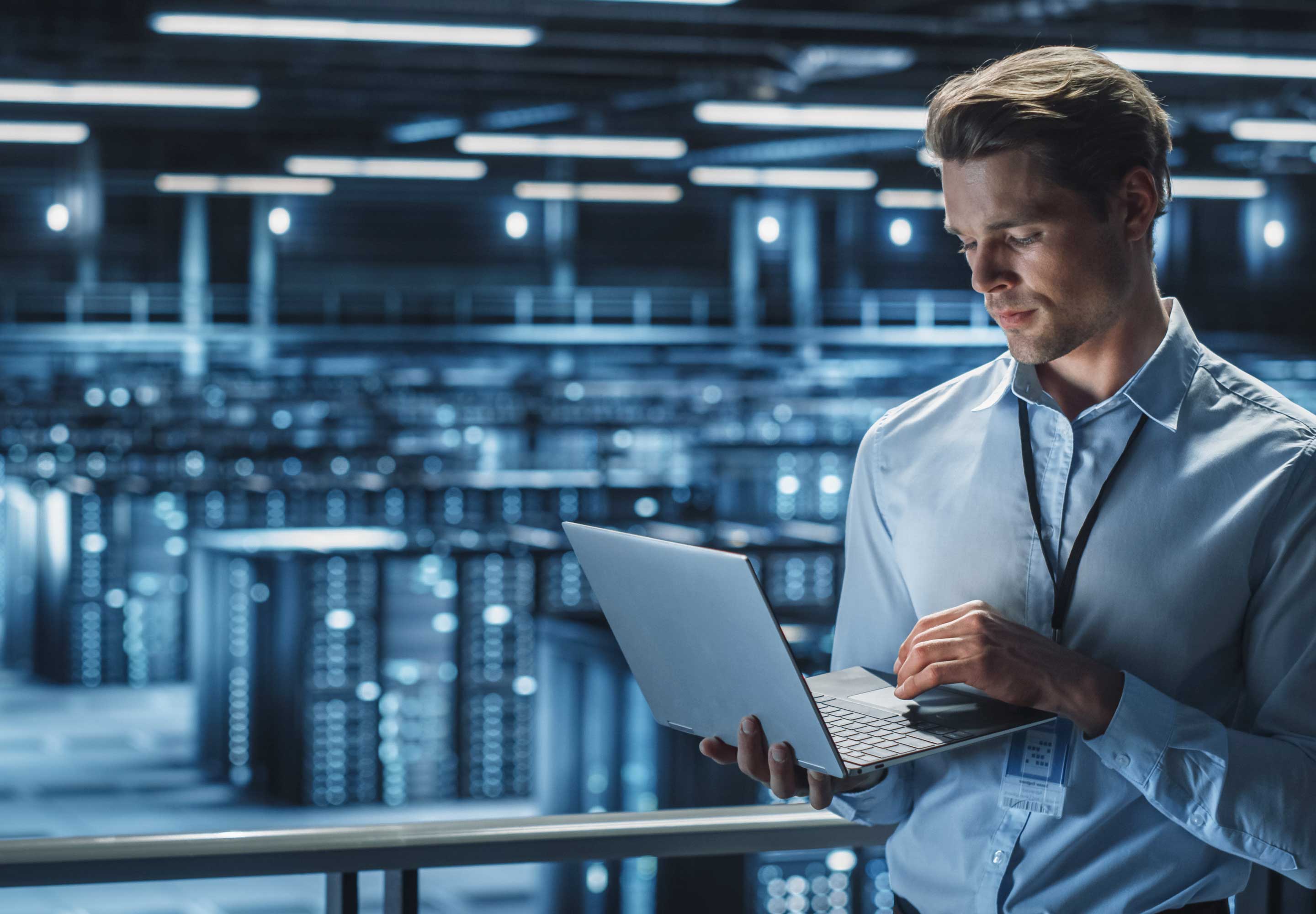 A man holding a laptop while standing