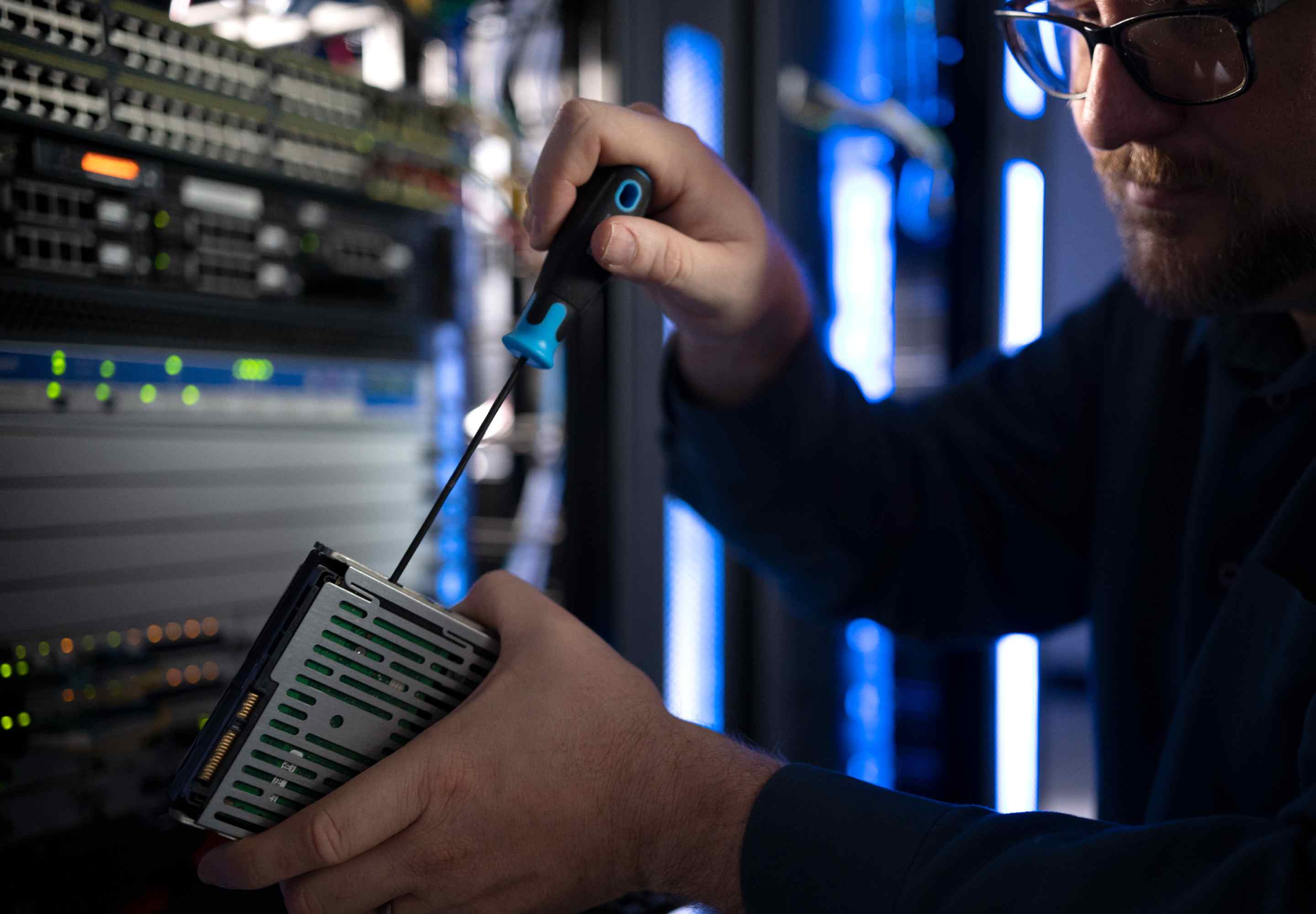 Tech works with a screwdriver on a Hard drive