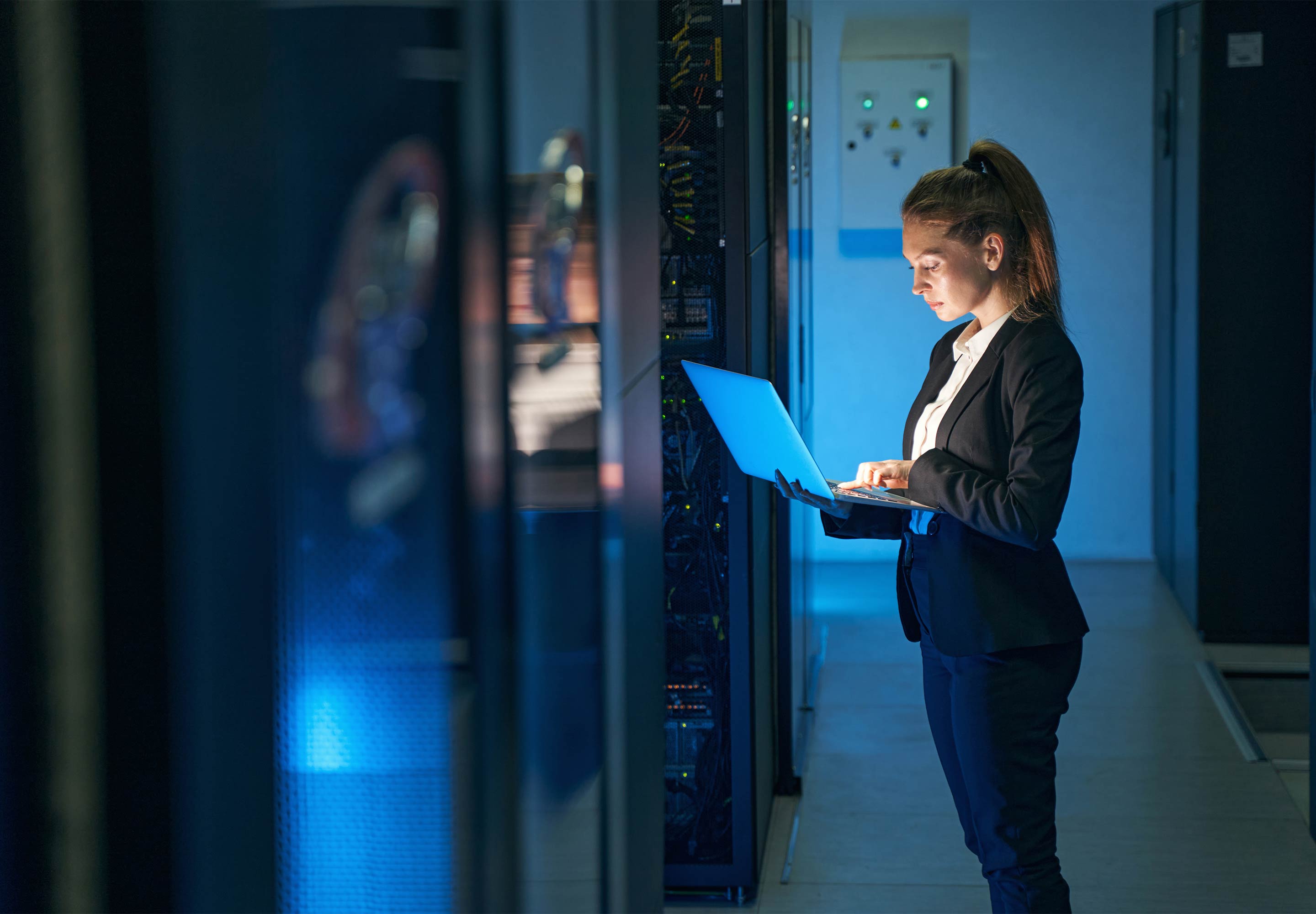Lady standing on the corridor with open laptop
