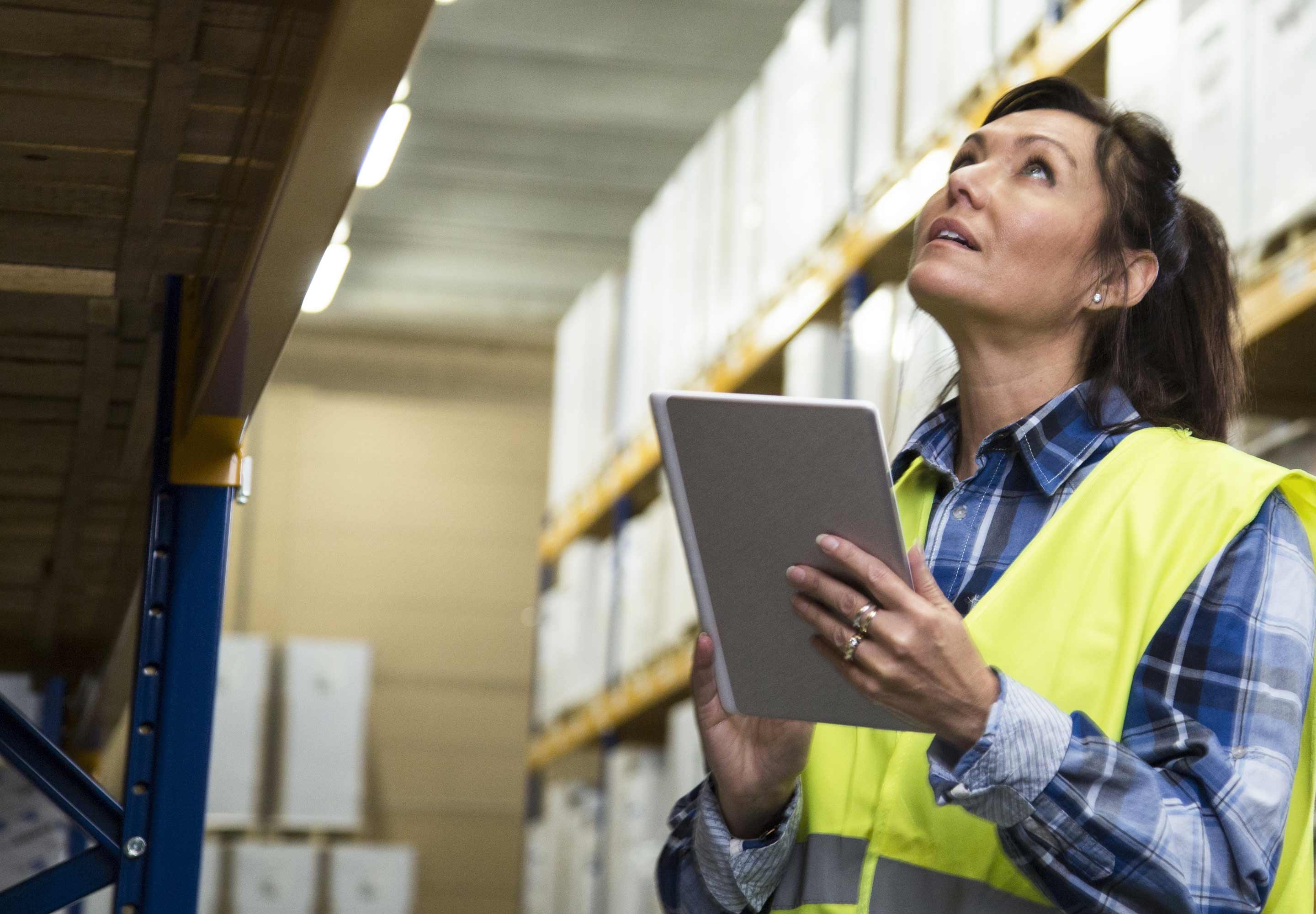 Woman checking a shelf with a tablet