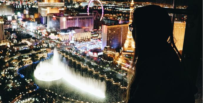 Woman looking through a window overlooking the city