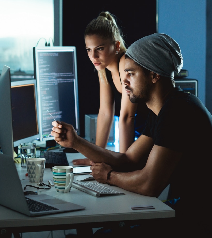 A man and a woman focusing on a screen monitor
